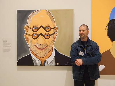 Thom Roberts with his painting A Portriff of Adam (Shane Simpson AM) hanging in the 2021 Archibald Prize. Photo: Studio A