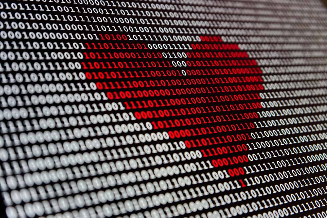 a red heart is shown on a computer screen of zeros and ones