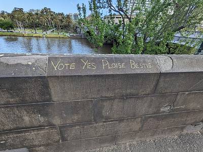 "Vote YES ploise bestie" written in chalk on a concrete wall